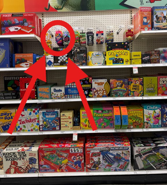 Photo of a Target shelf with a red circle and arrows pointing to the small hanging section above eye level where Speed Swap Chaos is located